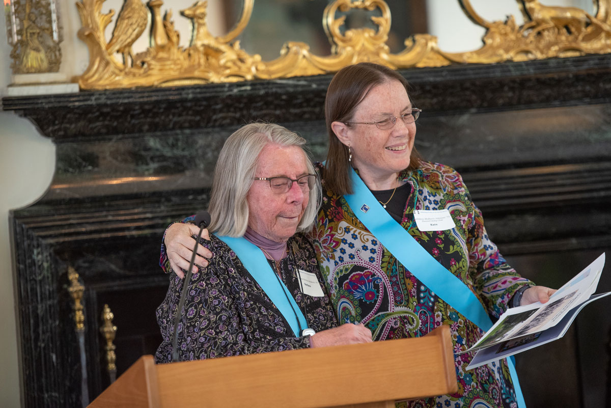 Former Chair of the Committee on Deferred Gifts and Bequests, Barbara Mulhern '47 and her daughter, Kate Mulhern Johnson '72, current Grécourt Chair, at the Society's 25th anniversary reception in 2019.  They are showing fellow members photographs of the original Grécourt Gates that stood before the Château de Robécourt in France.